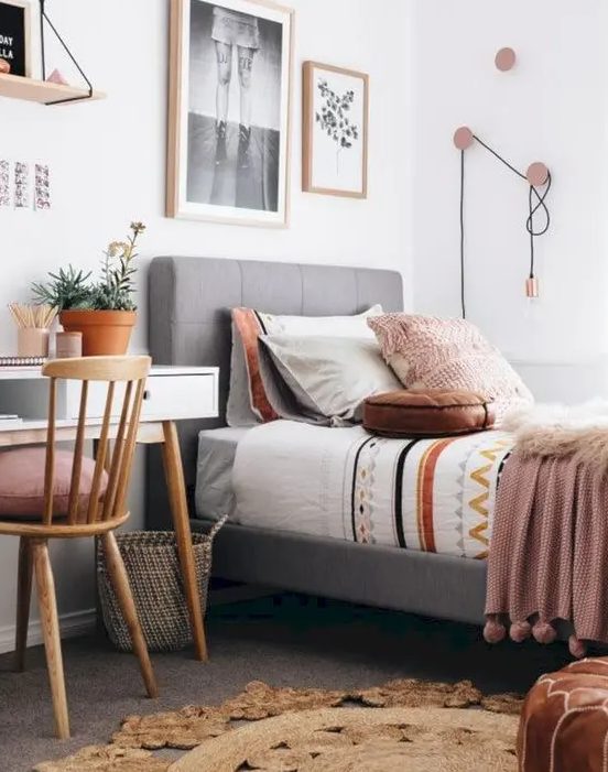 a stylish, modern teenager's room with an upholstered bed, a white desk, a wooden chair, a gallery wall and cool hooks