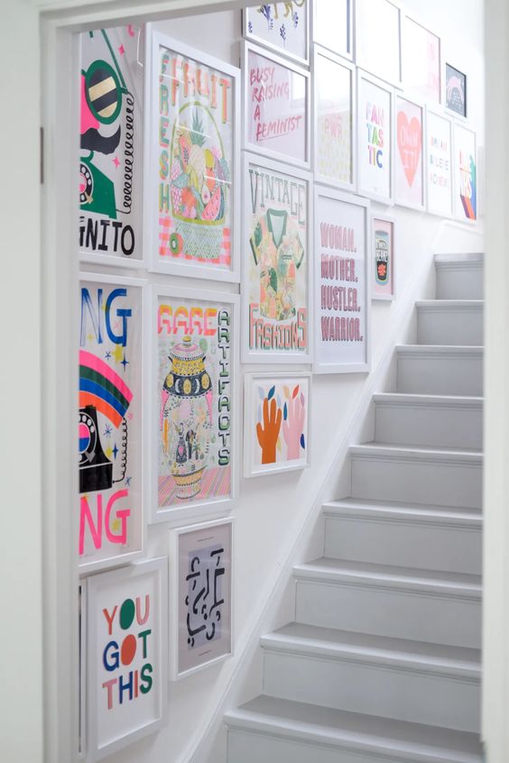 A super colorful gallery wall in the stairwell with bright posters is a cool and fun idea to make your space stand out