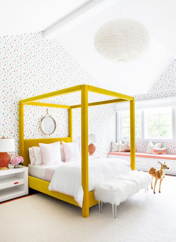 a whimsical, modern teenage girl's bedroom with bright wallpaper, a mustard four-poster bed with neutral linens, and a windowsill