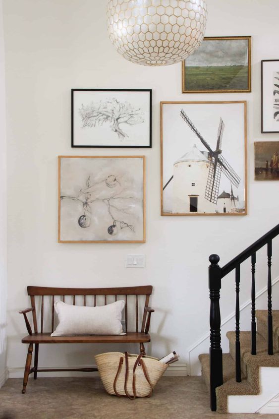 This beautiful gallery wall above the stairs features mismatched frames and lots of graphic art