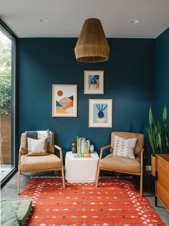 Cool midcentury modern chairs and a coffee table, a bright gallery wall, and printed textiles are great for a millennial living room