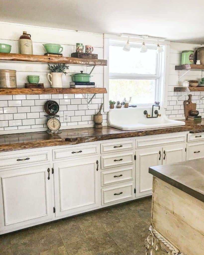 Rustic white cupboard kitchen with wooden worktop and white tile backsplash 