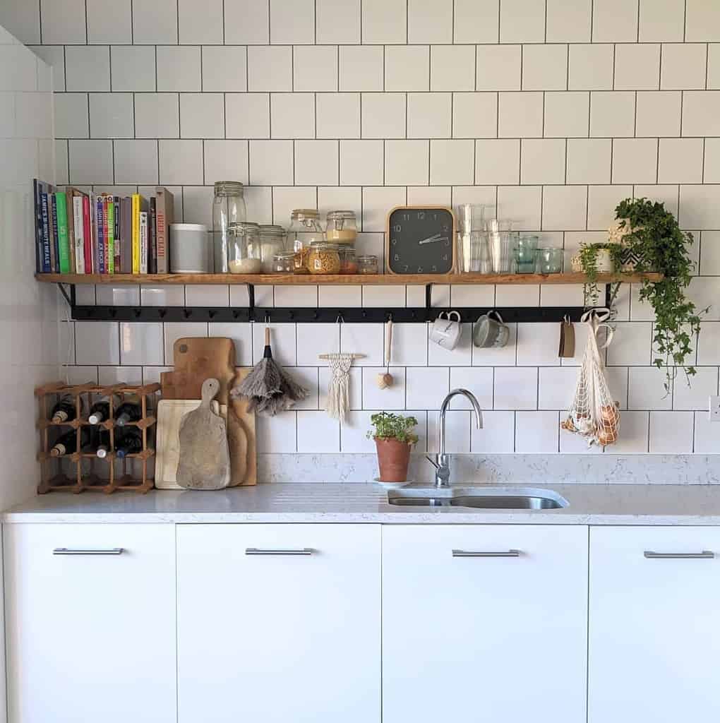 White tiled kitchen wall wooden shelf with watch glasses and cookbooks 