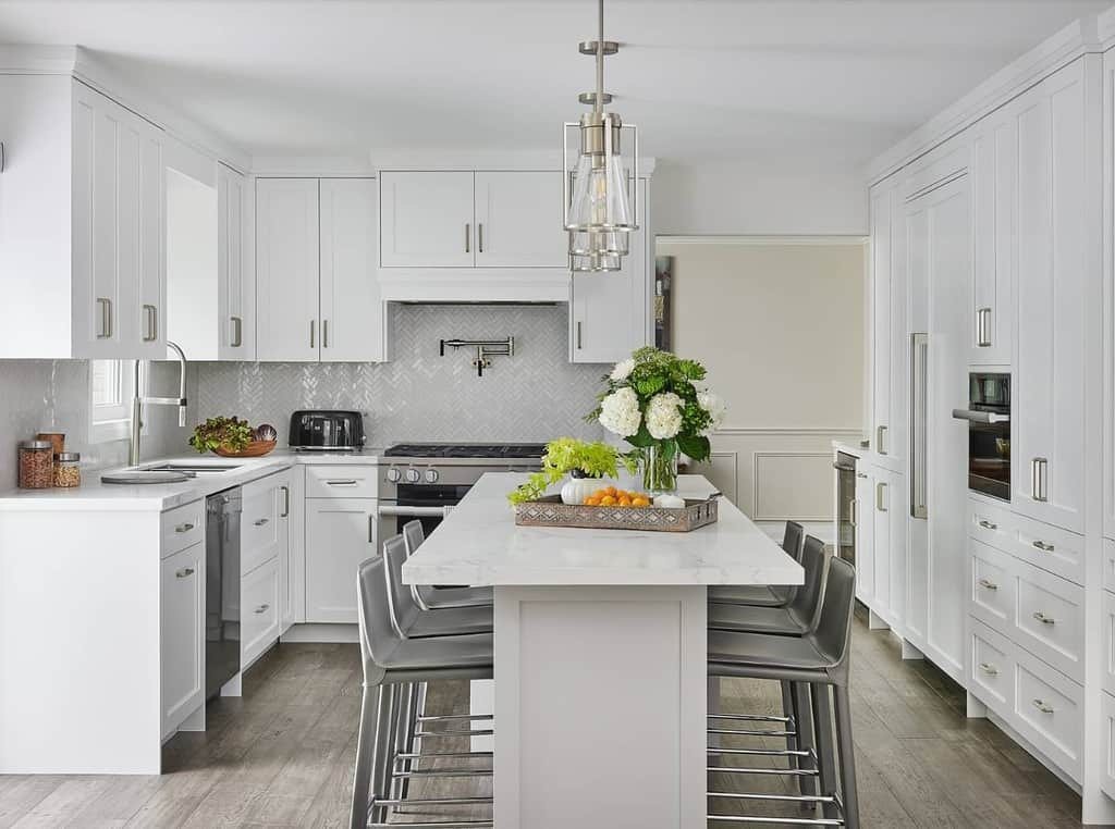 White cupboard kitchen with island and gray seats 
