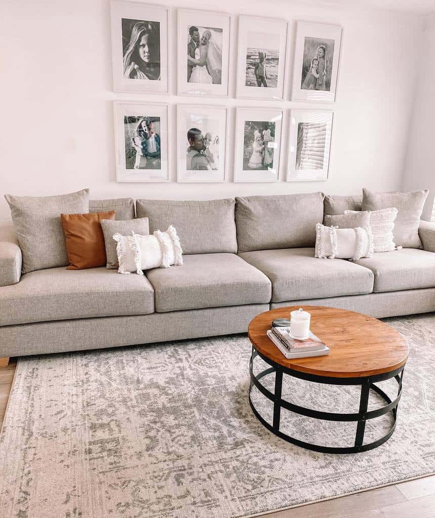 White living room with gray sofa and framed family photos on the wall