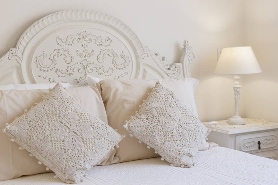 French country bedroom, white bedspread, bedside table and lamp