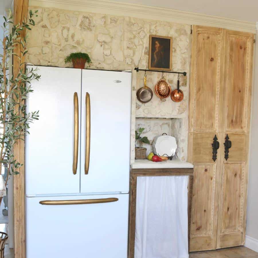 Rustic kitchen, white refrigerator, gold accents, hanging pans 