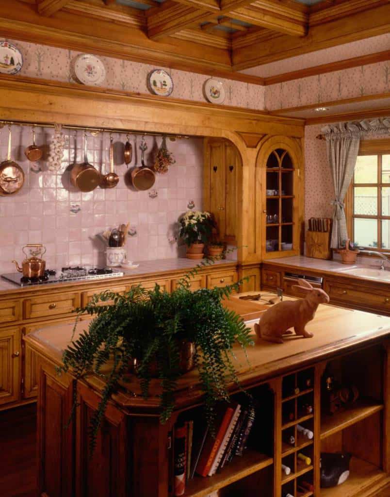 Kitchen backsplash made of wooden tiles, hanging copper pots and pans, rabbit statue 