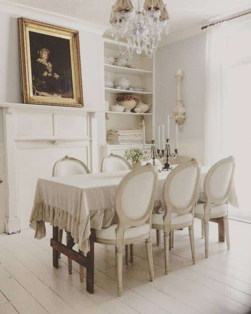 White country house dining room, long table, candlestick, white shelves, framed painting 