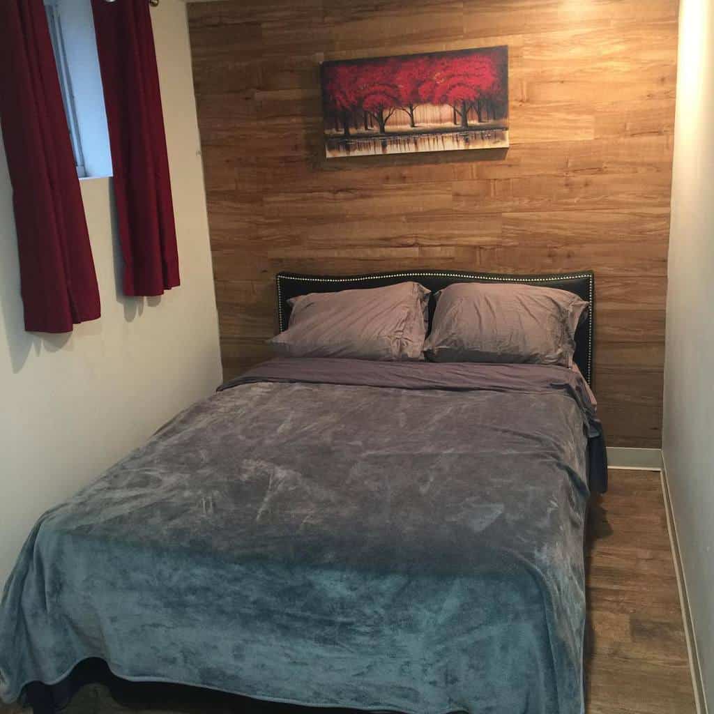 small bedroom with wooden wall panel 