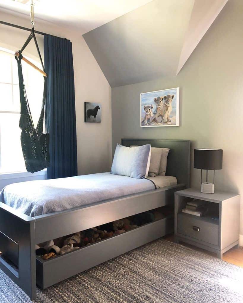 Gray bed with storage space underneath in a small room 