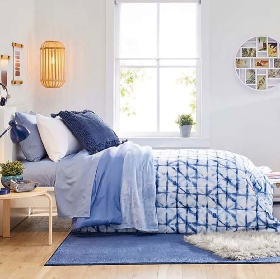 Blue bed in a small white bedroom 