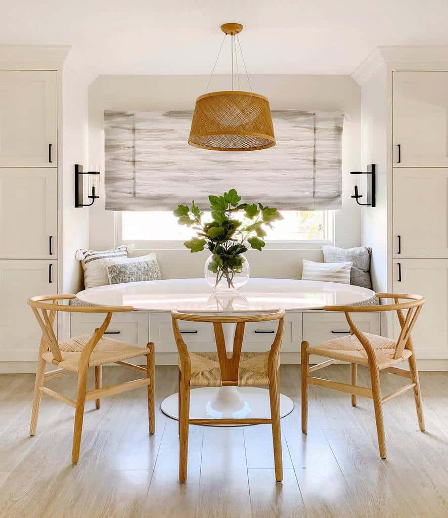 small white round dining room table with wicker chairs and lampshade