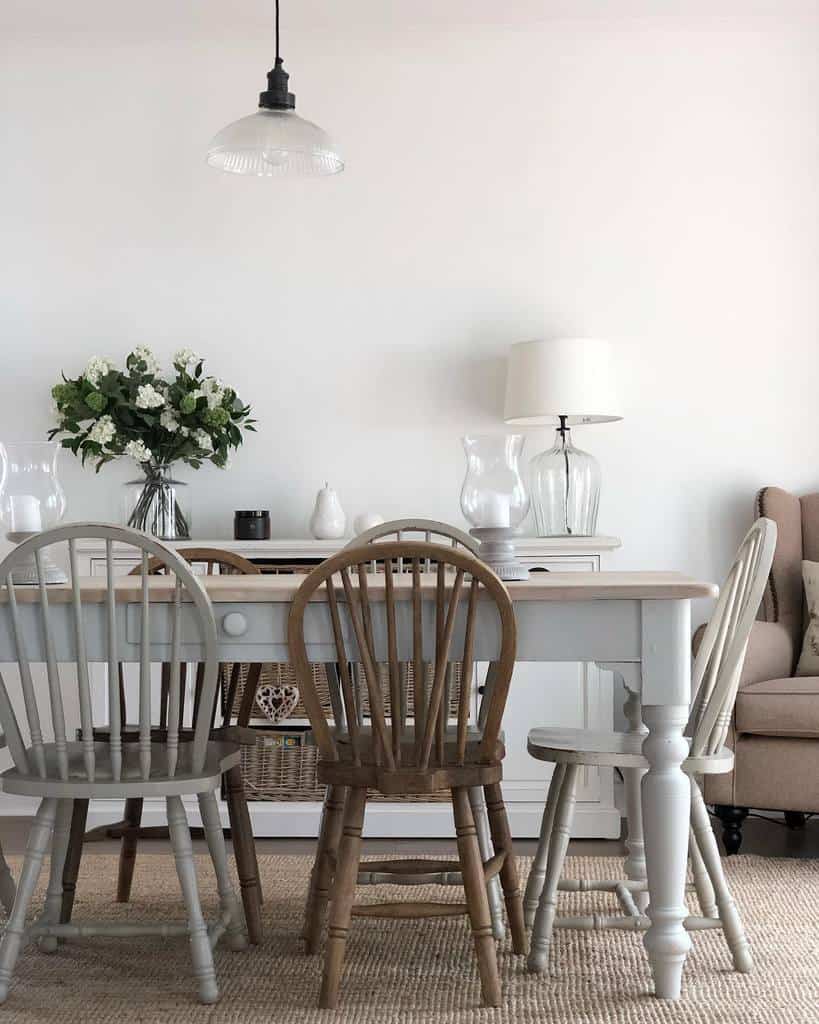 Simple dining table, mismatched chairs, candles, flowers