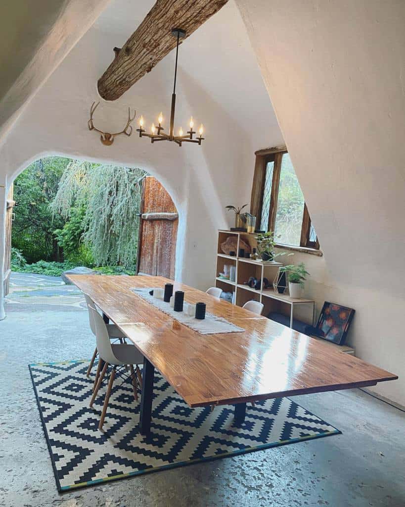 long wooden dining table, high ceilings, chandelier, concrete floor