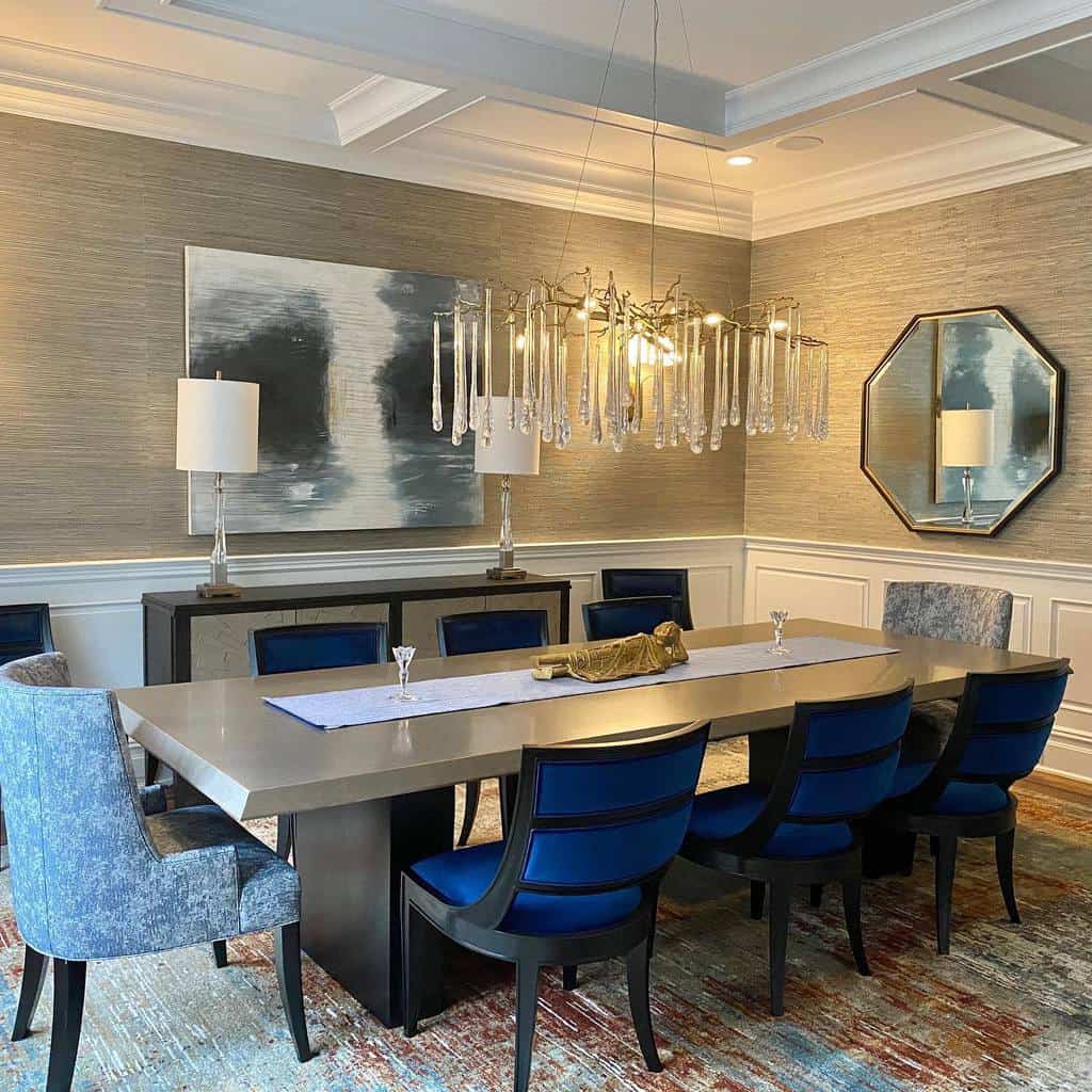 Transitional dining room, low chandelier, gray dining table, blue chairs 
