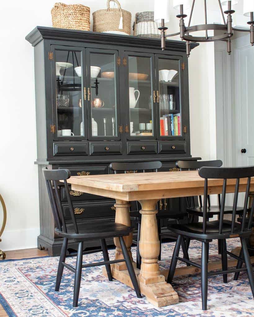 Rustic wooden dining room table, black chairs and cabinet chandelier