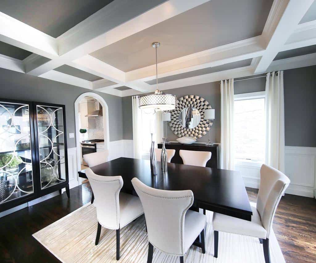 Modern dining room, black table, gray chairs, mirrored wall 