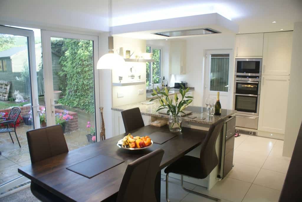 modern kitchen, dining room, wooden table, marble bar, fruit arrangement 