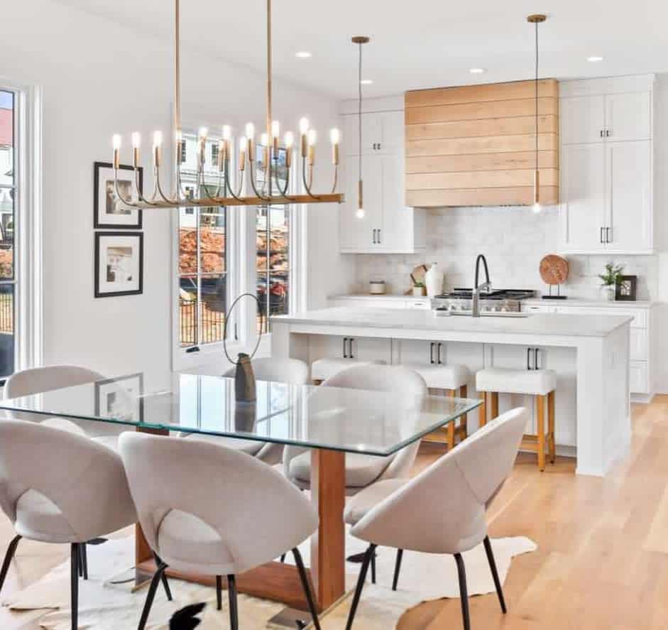 bright open kitchen and dining room, white cabinets and glass island table 