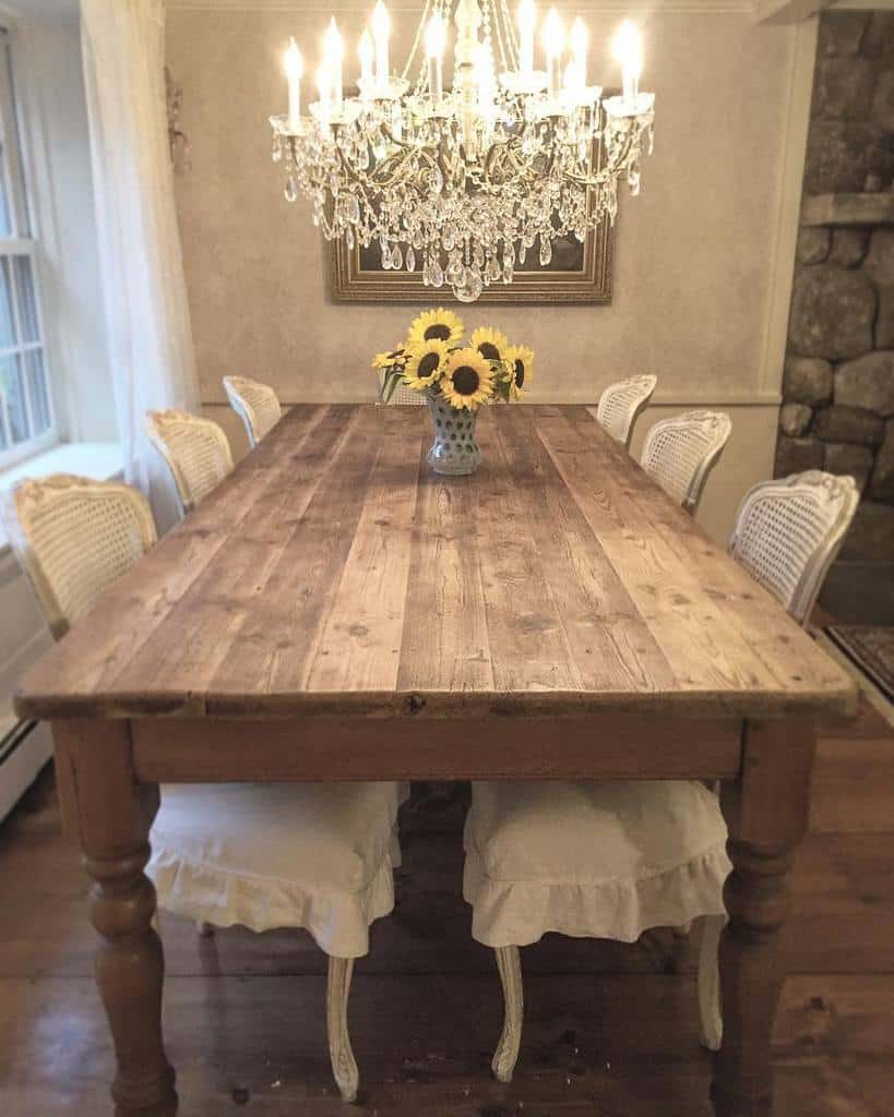 Traditional wooden dining table with flowers in vase, low hanging chandelier