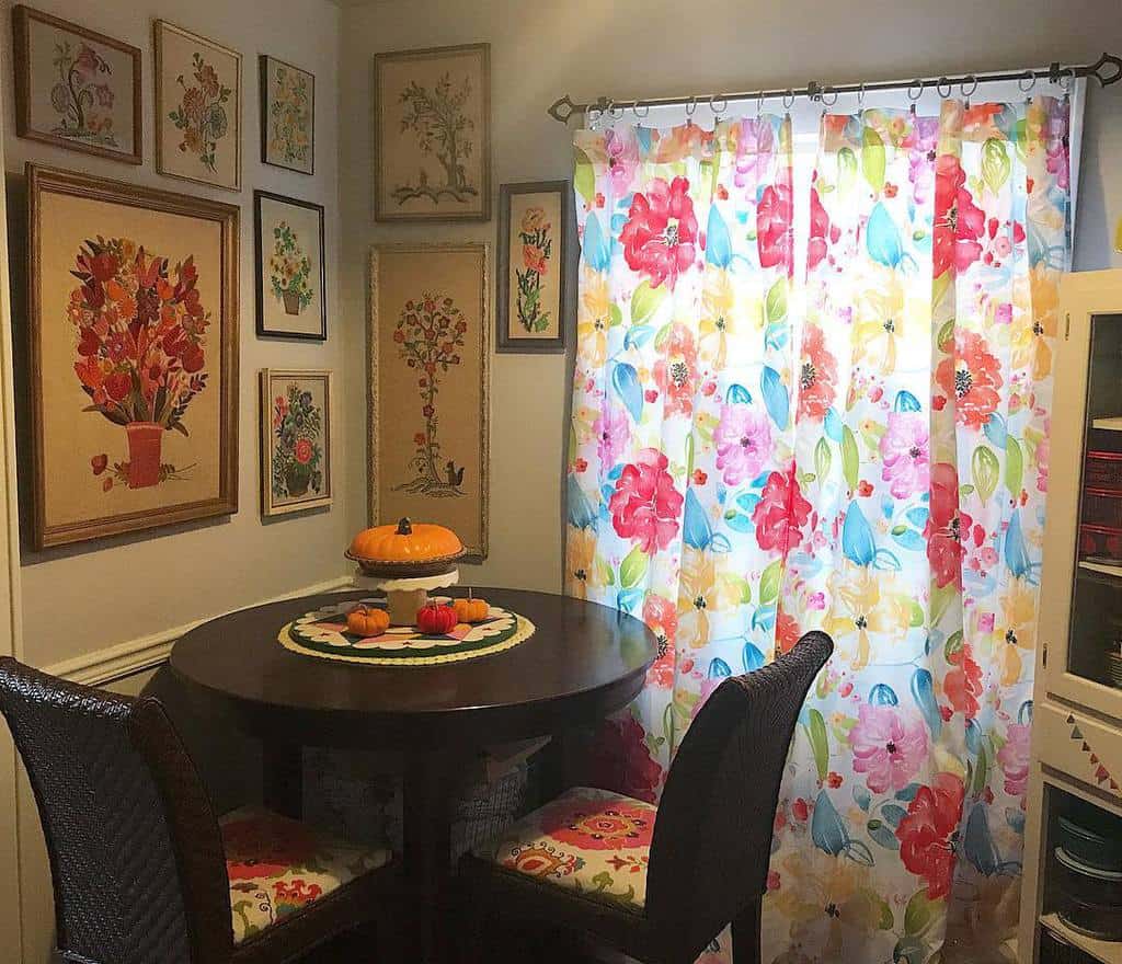 small corner table and chairs, floral curtains, framed floral wall art