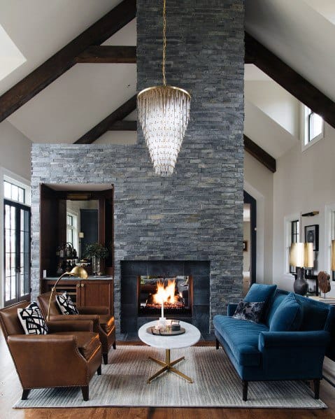 classic living room with large stone fireplace and glass chandelier