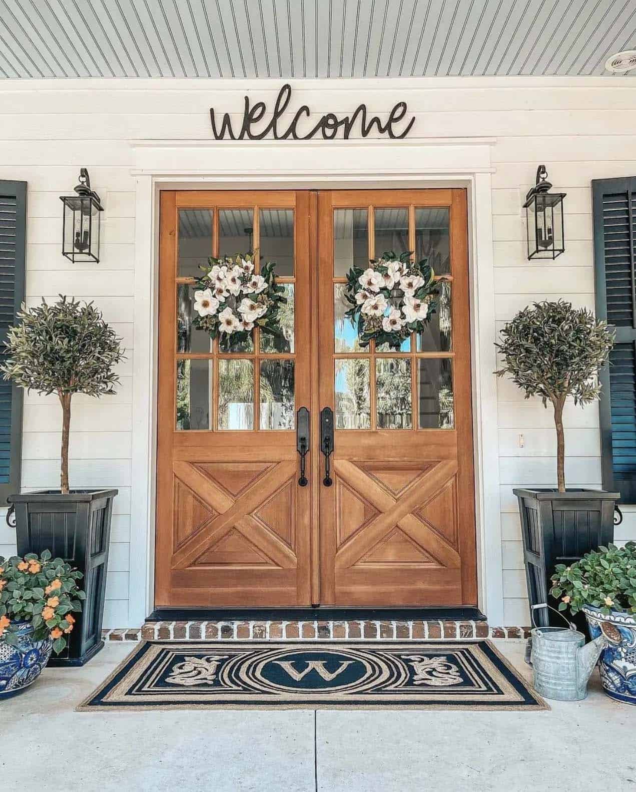 Inviting spring porch with olive topiaries and magnolia wreaths
