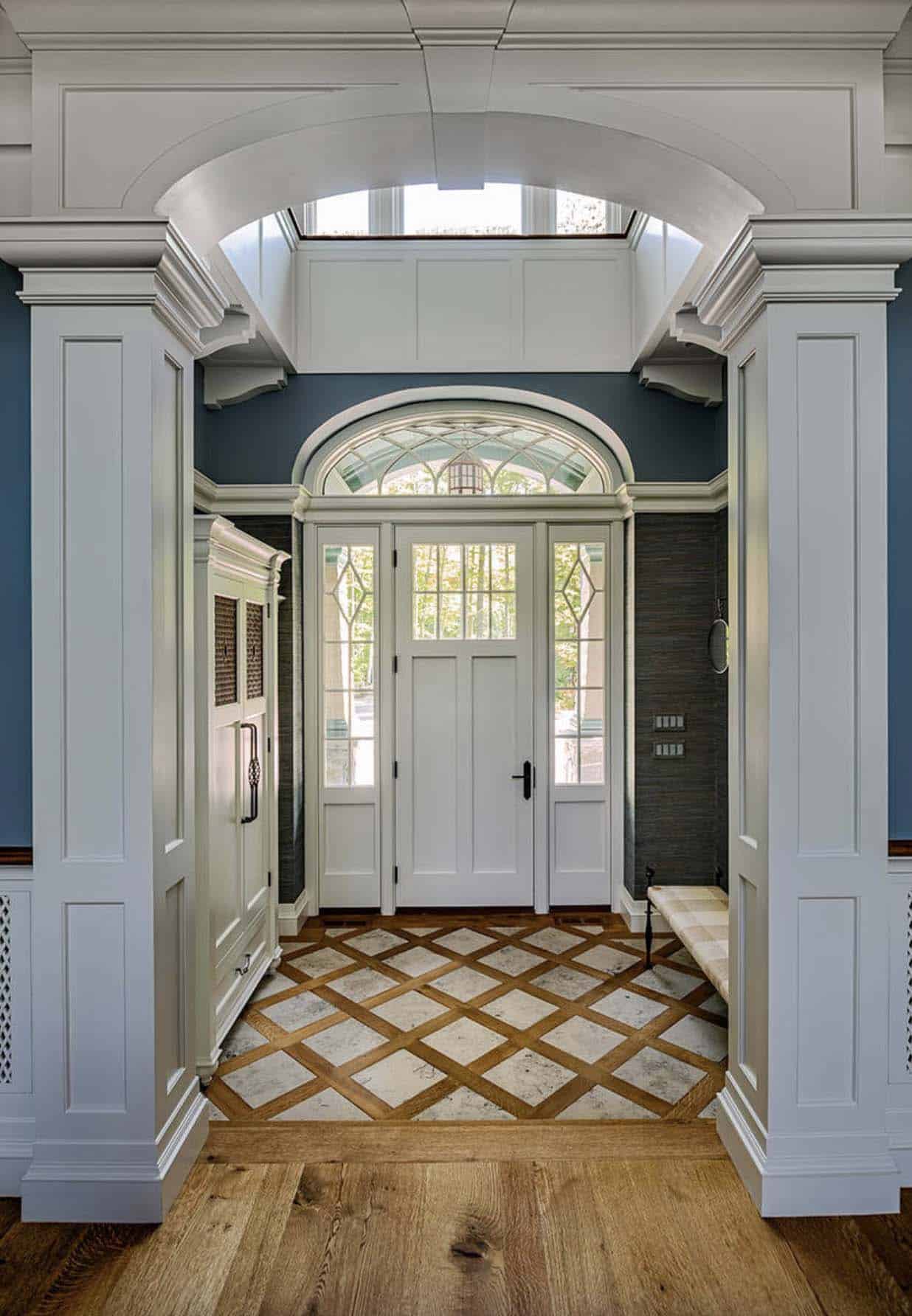Grand home entryway with tile and hardwood floors