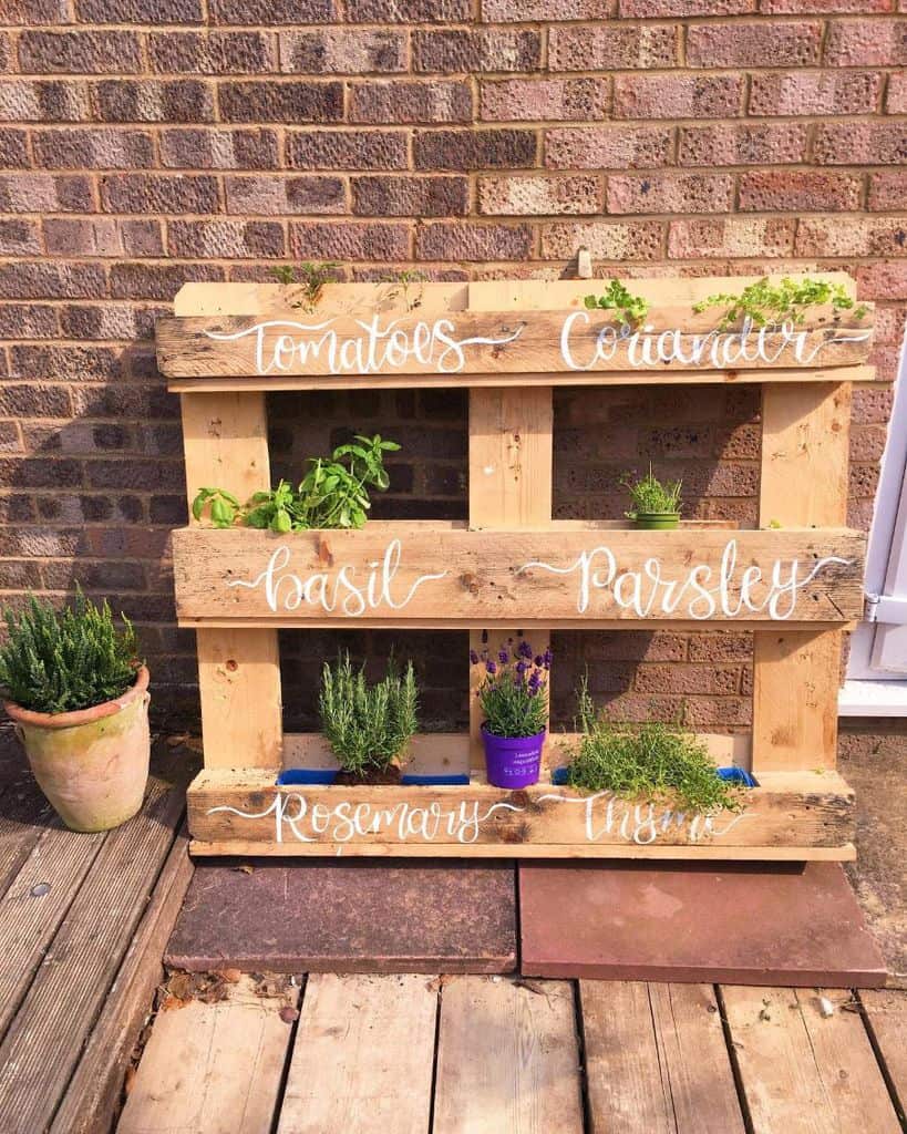 DIY pallet herb garden against brick wall