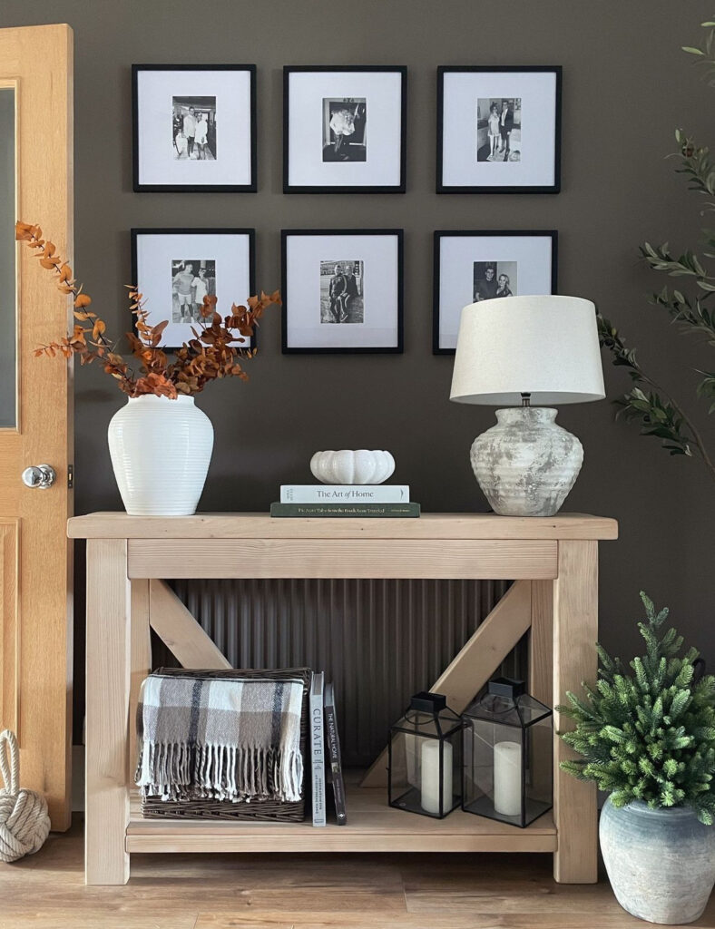 Entry table with gallery wall with family photos and blanket storage