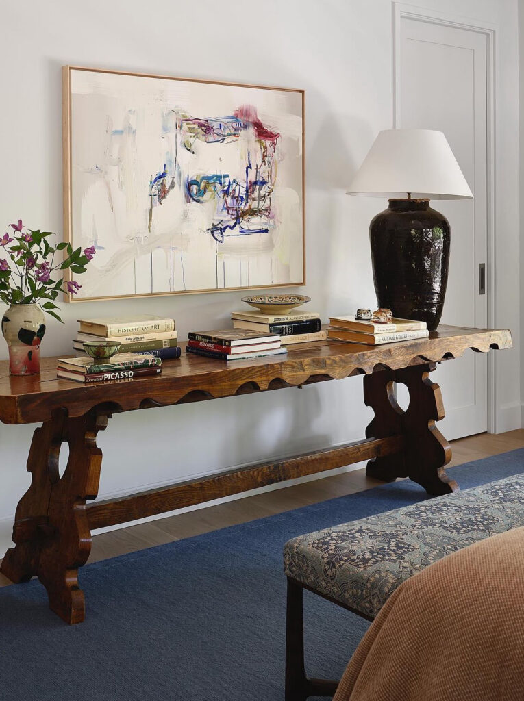 Entryway table with vintage books and modern abstract art