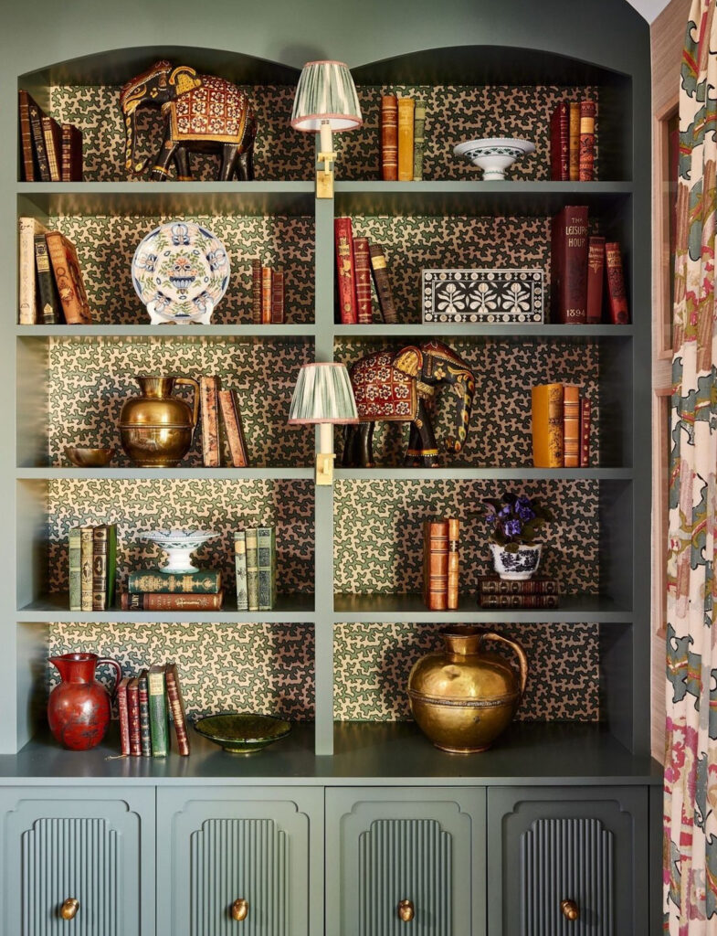 Teal built-in shelves with unique green and beige pattern wallpaper