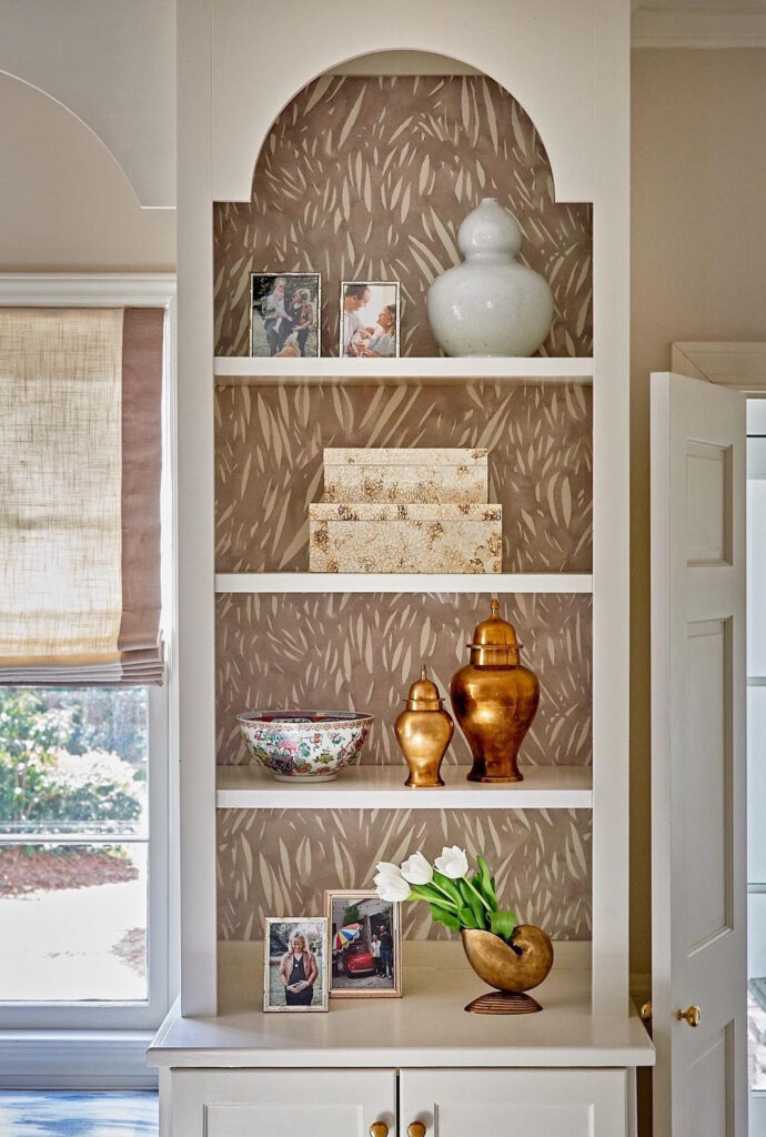 Simple modern taupe patterned wallpaper on arched built-in shelves