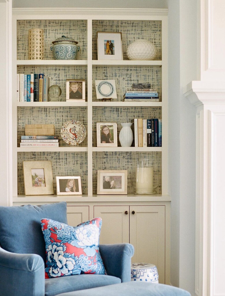 Beige shelves with subtle blue patterned wallpaper inside