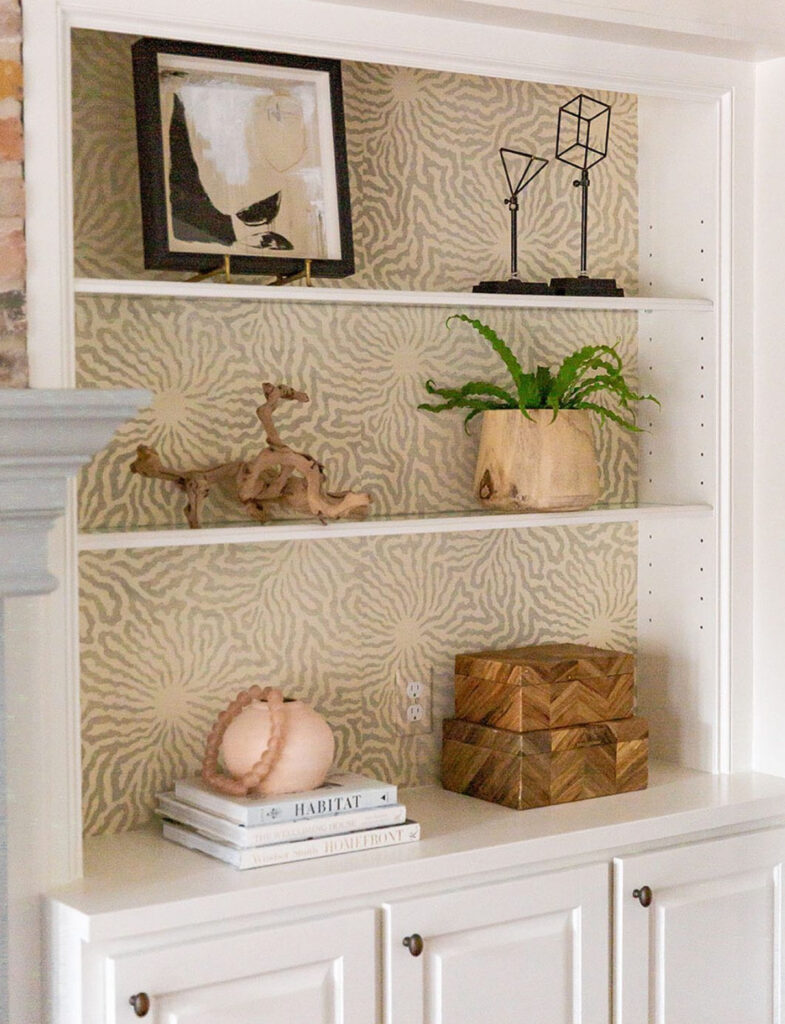 Simple yellow and taupe textured wallpaper on white shelves