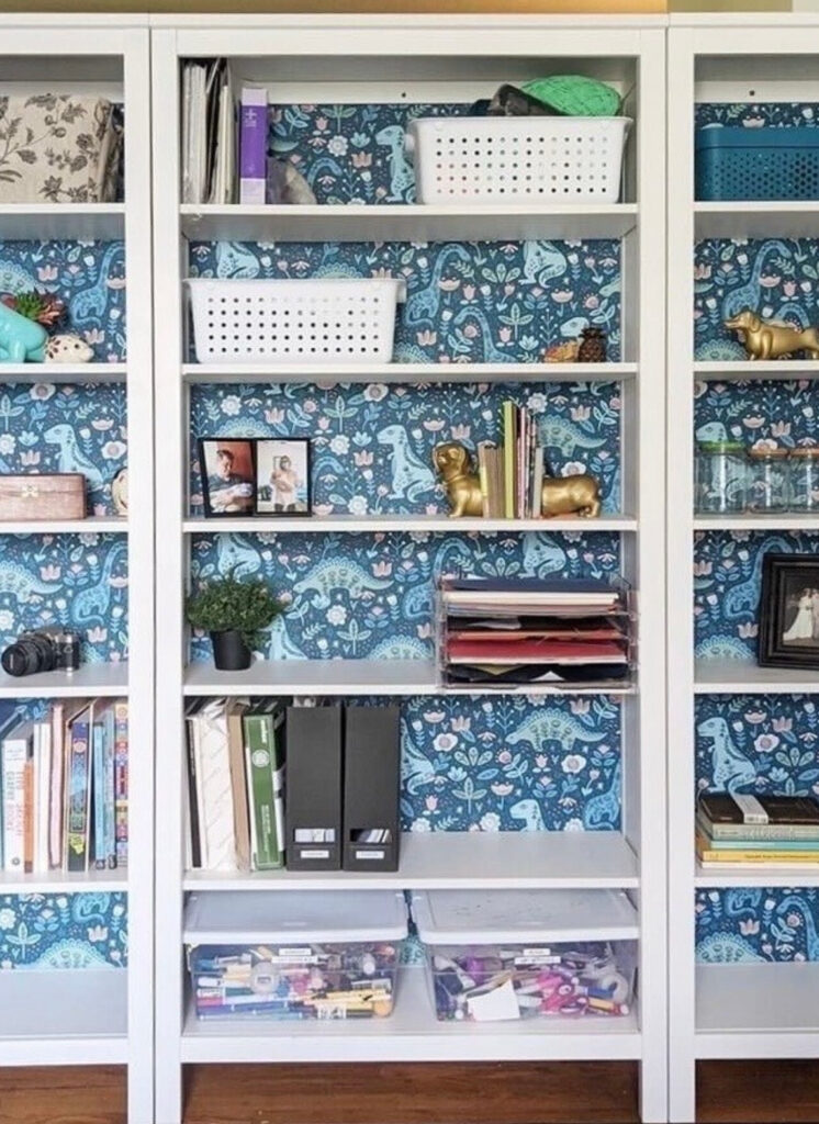 Blue dinosaur wallpaper on the playroom bookshelves