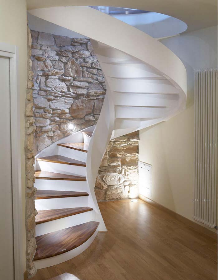 Natural wall combined with modern spiral staircase