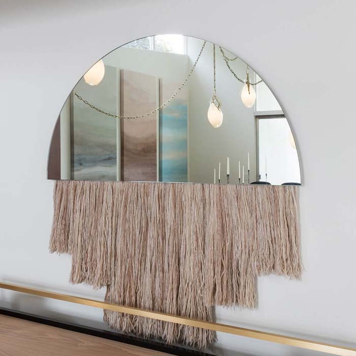 Wall art with a half-round mirror and macrame