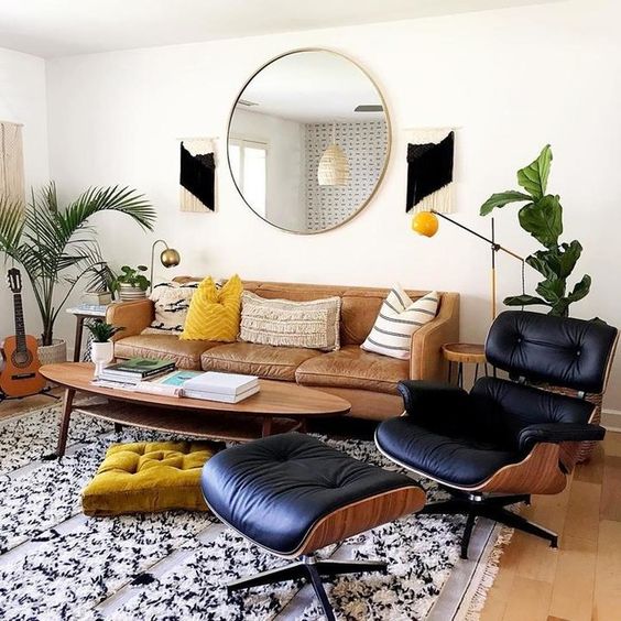 A stylish mid-century modern living room with a leather sofa, a beautiful oval coffee table and a black daybed