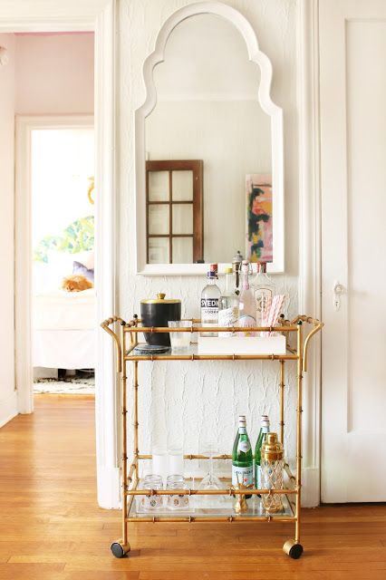 An elegant golden bamboo bar cart is a stylish addition and a must-have for a millennial living room