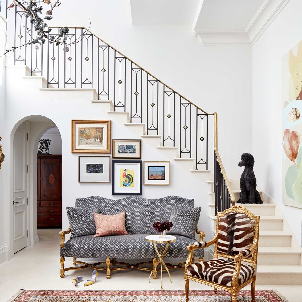 The family's French poodle Hugo greets guests in the double-height foyer, and framed works by Canadian artists hang above a velvet sofa