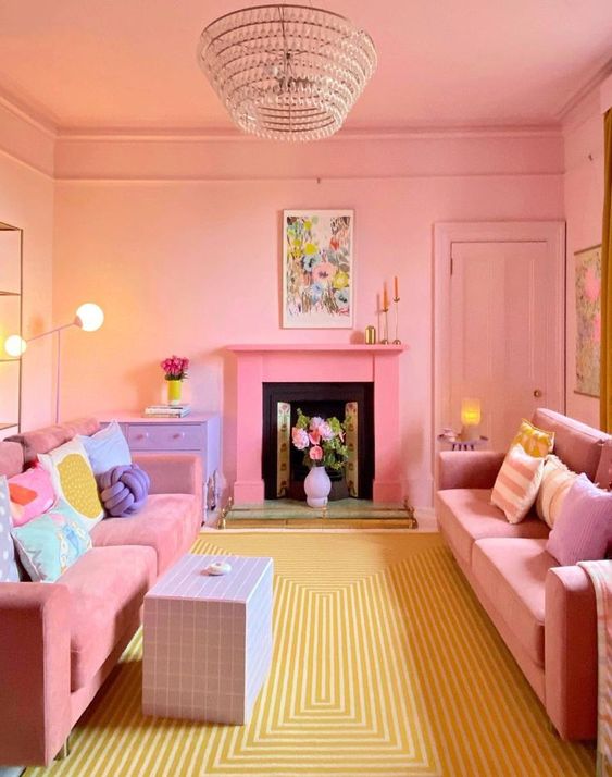 A bright living room in dopamine decor with pink walls and ceiling, pink sofas and pastel pillows, a purple table and a pink fireplace