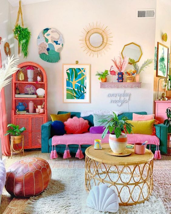 a colorful dopamine living room with a teal sofa and colorful pillows, a coral sideboard, greenery and eye-catching decor