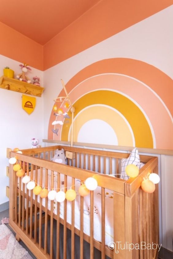 a colorful nursery with an orange blanket, a crib, a statement accent wall, a shelf, and some toys and decorations