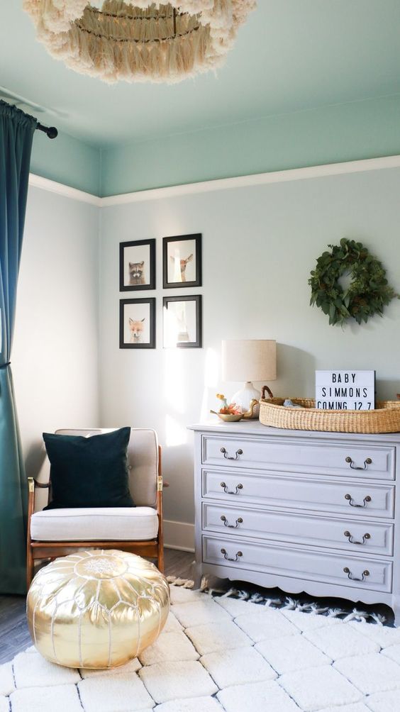 a cozy children's room with light green walls and an aqua blue ceiling, a gray dresser, a rattan chair and a fringed chandelier