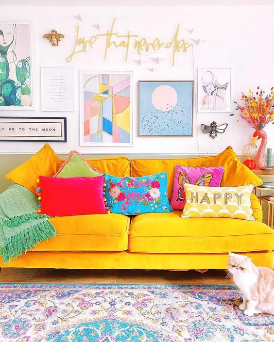 a dopamine living room with a sunny yellow sofa and colorful pillows, a printed rug and a statement gallery wall