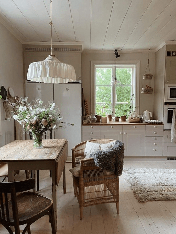 a neutral Nordic kitchen with butcher block countertops and a stained dining set, a hanging lamp above the table