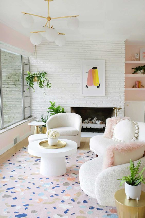 a playful living room with a glazed wall, a fireplace, a white bouclé sofa with cushions, a curved chair and a terrazzo print rug