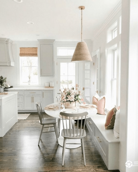 A serene, modern farmhouse kitchen with shaker cabinets, a windowsill, and a table and chairs is beautiful